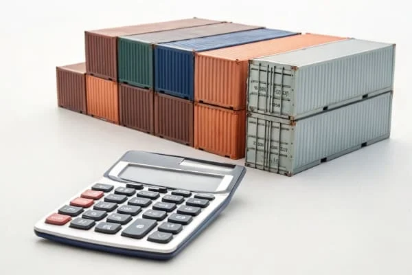 A calculator and shipping containers to represent shipping costs