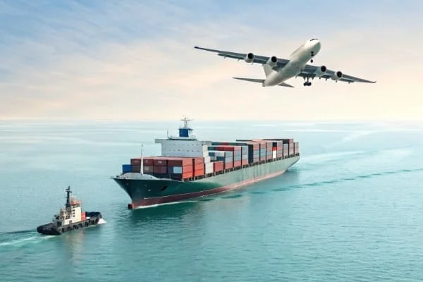 Cargo ship with containers on ocean watched by a plane flying overhead, indicating global shipping and logistics.