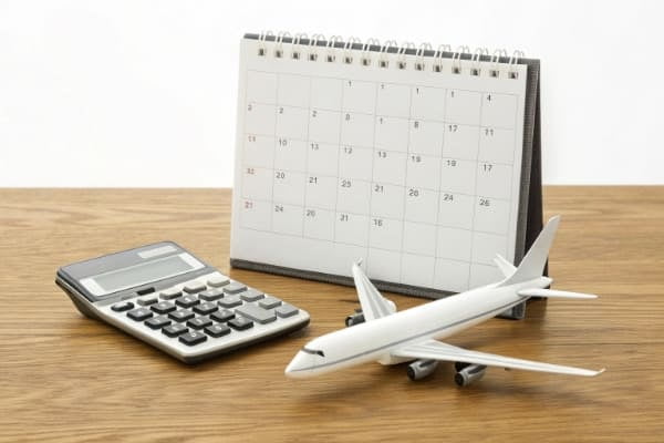 A calculator and a calendar next to a model airplane