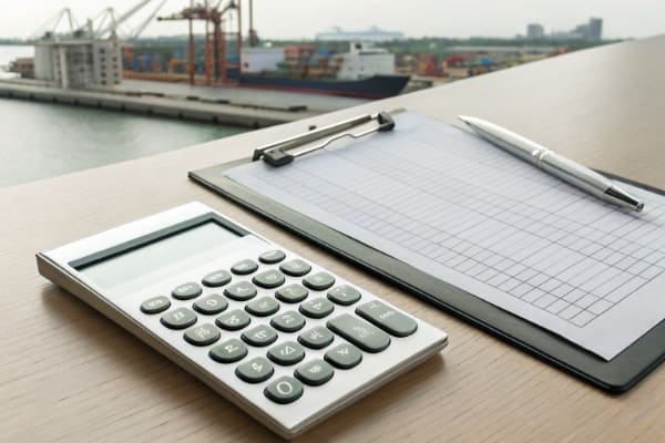 A calculator and shipping documents to represent shipping costs