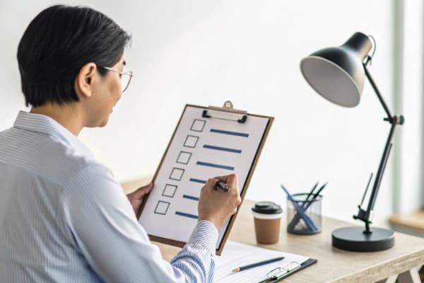 A person reviewing a checklist to select a freight forwarder