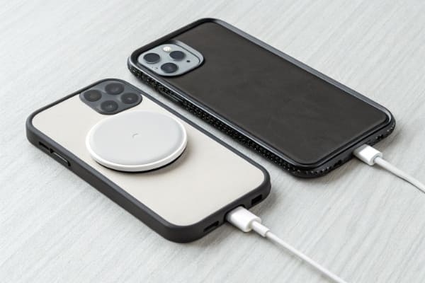 A comparison of a phone with a MagSafe case and a non-MagSafe case on a charger
