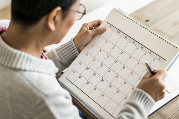 A person looking at a calendar with Chinese holidays marked
