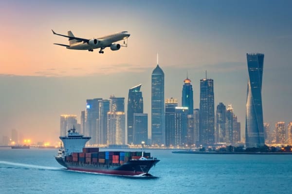 A cargo ship and airplane heading towards the skyline of Doha, Qatar