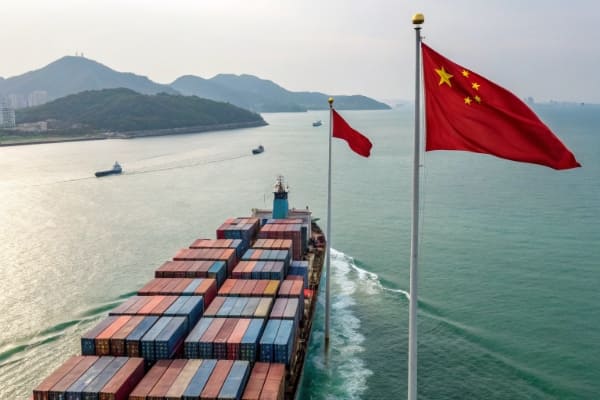 A container ship sailing towards Qatar with the Chinese and Qatari flags visible
